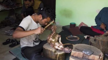 Geleneksel Budist bronz heykellerinin yaratılmasında usta. Çekiç knocks ve Tara dekoratif unsurları toz kapalı darbeler. Nepal, Katmandu, 7 Mart 2017 tarihinde.