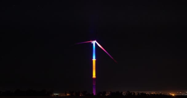 Ostrza Ogromnego Generatora Wiatrowego Obracają Się Belkach Kolorów Nocnego Oświetlenia — Wideo stockowe