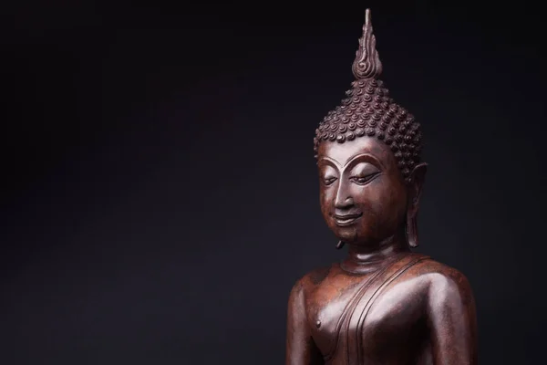 Standbeeld van Boeddha gemaakt van hout op zwarte achtergrond. — Stockfoto