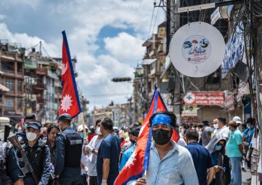 14 Haziran 2020, Katmandu, Nepal. Nepal 'de polis ve protestocuların yozlaşmaya ve Coronavirus' a karşı etkisiz mücadelesine karşı arka planda Nepal bayrağı taşıyan maskeli bir adam görülüyor..