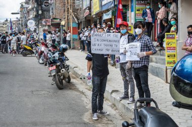 June 14, 2020, Kathmandu, Nepal. A youngers holding a poster apologizing for the inconvenience caused by an try to change the system on a demonstration against corruption and the ineffective fight against coronavirus in Nepal. clipart