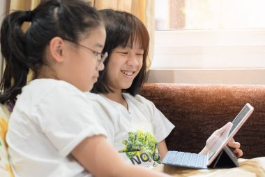 Okul çocuğu, kız çocuklar evde internet üzerinden internet üzerinden öğrenim görüyor, mobil tablet uygulaması hakkında e-kitap okuyor veya dijital teknolojide oyun uygulaması oynuyorlar.