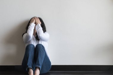 Anksiyete bozukluğu olan menopoz hastası, stresli depresyonlu, ruh hastası, baş ağrısı ve migreni olan bir kadın. Evinde yerde sırtı duvara dönükken kendini kötü hissediyor.