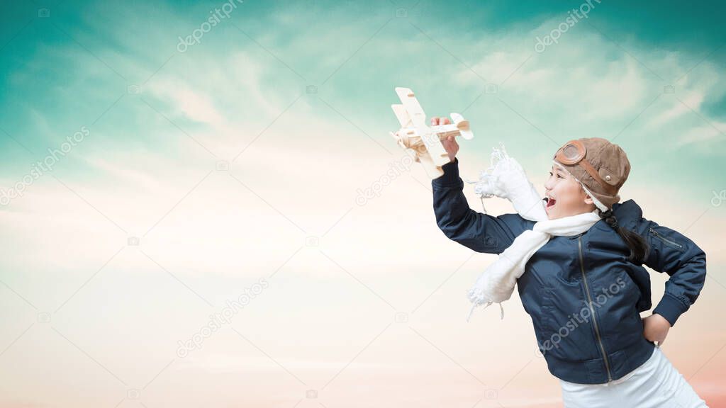 Girl child in pilot costume having fun with creative learning motivation, imagination and inspiration dream high playing flying plane toy over blue sky background