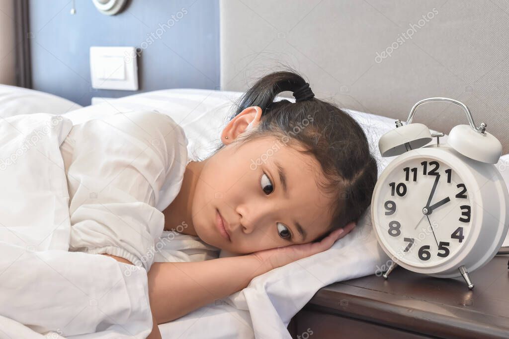 Asian girl child in bed do not sleep suffering insomnia (sleeping disorder) at night in bedroom