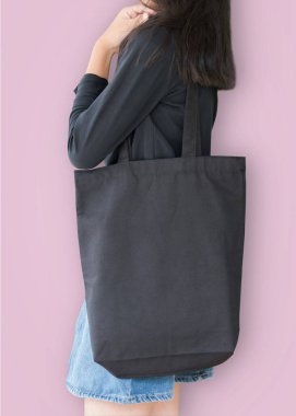 Siyah taşıma çantası modelleme şablonu pamuk bez kumaş deseni kız omuz üzerinde (kırpma yolu ile izole) pastel pembe arka plan üzerinde