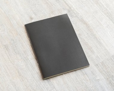 Ahşap masa üzerinde boş siyah deri kaplama şablon kağıt desenli maket kitap 
