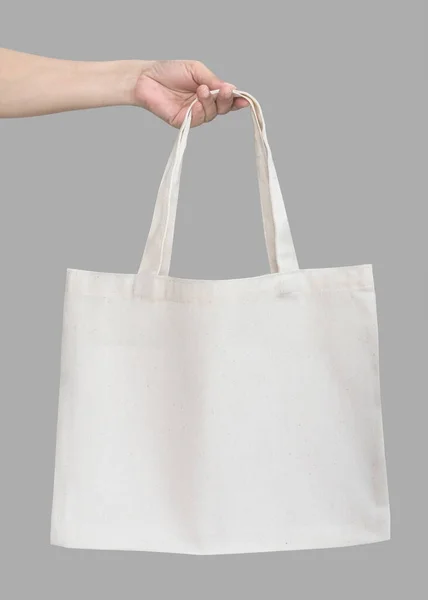 Tote bag canvas white cotton fabric cloth eco shopping sack mockup blank template isolated on grey background (clipping path) with woman handling hand