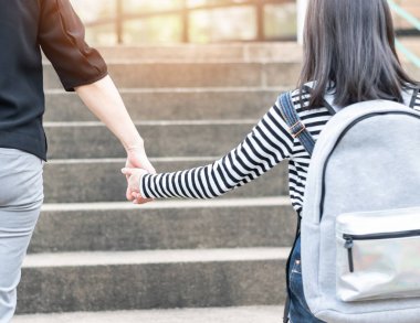 Eğitici okula geri dönmek ya da ilkokul öğrencisinin aile üyelerinin elini tutan sırt çantalarını taşıması ya da okul müdürlüğünden sınıfa giriş binasına kadar yürümesi.