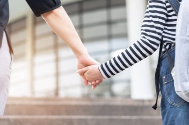 Eğitici okula geri dönmek ya da ilkokul öğrencisinin aile üyelerinin elini tutan sırt çantalarını taşıması ya da okul müdürlüğünden sınıfa giriş binasına kadar yürümesi.