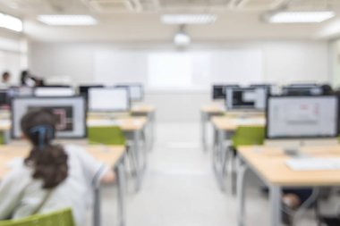 Bilgisayar laboratuarının arka planı iş yerindeki insanlarla bulanıklaşır ya da bilgisayarlı bilgisayarla öğrenen öğrencilerle bulanık ofis çalışma alanı ya da sınıfın arkasından sınıf perspektifi