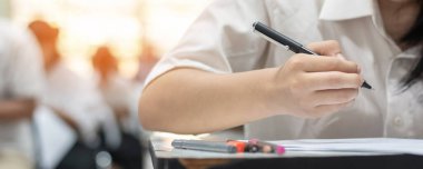 Okul öğrencisi sınava giriyor, çok düşünüyor, eğitim üniversitesine kabul sınavı ve dünya okur yazarlık günü konsepti için sınıfta cevap yazıyor.