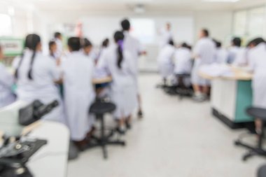 Biyoloji veya kimya bilimi dersi mikroskop ve öğrenci grubunun bulanık geçmişiyle bulanık laboratuvar sınıfında eğitim konsepti öğretmeniyle birlikte.