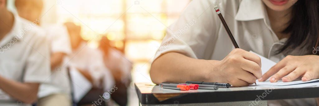 Exam with school student's taking educational admission test in class, thinking hard, writing answer in university classroom, education and world literacy day concept