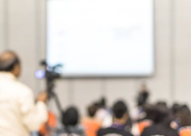 Seminer bulanık arka plan eğitim atölyesi video kameraman, konuşmacı iş konuşması yapan konuşmacı, sunum konuşması ya da konferans salonundaki seyircilerle eğitim konferansı