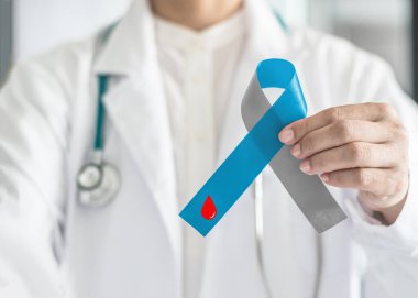 Diyabet Bilinci Dünya Diyabet Günü kurdelesi mavi ve gri fiyonk üzerine kırmızı kan damlası ile diyabetik tip 1 hastalığı olan hastayı desteklemek için doktor elinde
