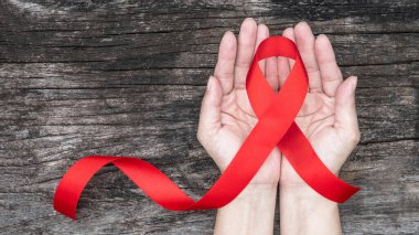Dünya yardımları günü ve ulusal HIV / AIDS ve kadınların el desteği için kırmızı kurdele ile yaşlanma farkındalığı ayı (kırpma yolu ile izole yay)