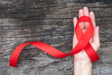 Dünya yardımları günü ve ulusal HIV / AIDS ve kadınların el desteği için kırmızı kurdele ile yaşlanma farkındalığı ayı (kırpma yolu ile izole yay)