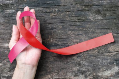 Pembe kurdele - HIV AIDS ve göğüs için sembolik renk yayı, rahim kanseri hastalığı farkındalığı üzerine kırmızı kurdele (kırpma yolu ile izole edilmiş)