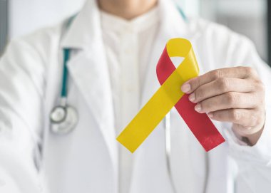 Dünya Hepatit Günü ve HIV / HCV ortak enfeksiyon farkındalığı ile tıp doktorunda kırmızı sarı kurdele el yay rengi hastalıklı ve hepatik hastalıklı hastaları desteklemek için