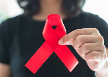 Dünya Yardım Günü ve Ulusal HIV / AIDS ve Yaşlanma Bilinci Ayı konsepti için kadınların el desteğine kırmızı kurdele takıyor