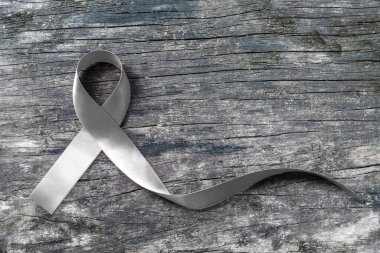 Parkinson hastalığı farkındalığı ve beyin kanseri tümörü hastalığı için eski ahşap üzerine gümüş renkli kurdele (kırpma yolu ile izole)