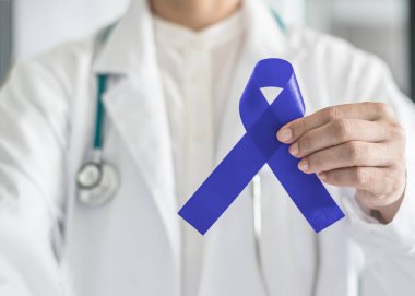 Kolon kanseri için koyu mavi kurdele - Tıp doktorunun el desteği konusunda kolorektal kanser farkındalığı