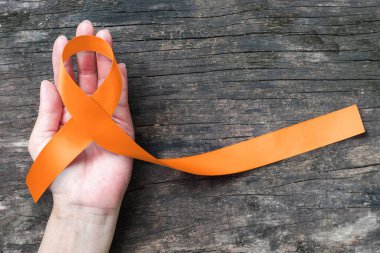Yaşlılık geçmişi üzerine turuncu kurdele lösemi, böbrek kanseri, RSD çoklu skleroz saten kumaş renk konsepti tümör hastalığıyla yaşayan insanlara halkın desteği için sembolik konsept