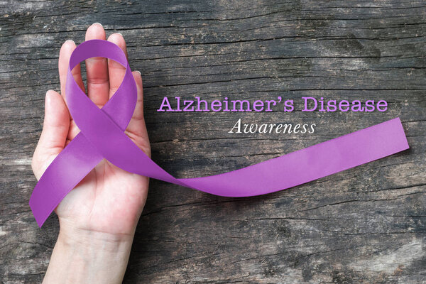 Болезнь Альцгеймера (AD) Осведомленность с фиолетовой лентой (обрезка пути) о помощи в ручной поддержке концепции Всемирного дня Альцгеймера (месяц)