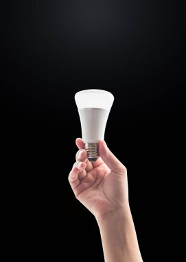 Kadın elinde LED ışığı ile enerji konsepti kaydediliyor siyah arkaplanda kırpma yolu ile izole