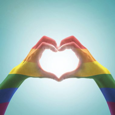 Gökkuşağı rengi bayrak deseni, mavi renkli arka planda kalp şeklinde şekillenen kadın eli: LGBT toplumunun aşk ve evlilik sosyal eşitliği ve insan kavramında sembolik eşit haklar