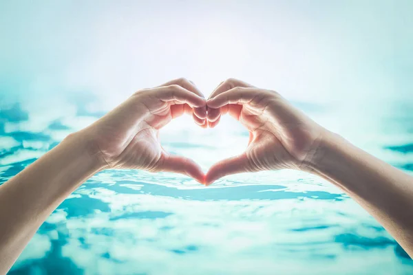 友情と水と海の概念を保存するための愛の心の形で手 — ストック写真