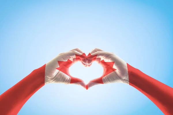 Canada flag pattern on people hands in heart shape for national public holiday celebration concept