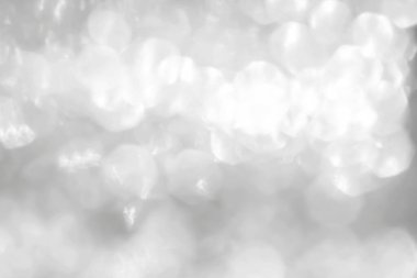 Kış tatili dekorasyonu için ışıl ışıl parlayan parlak beyaz ışığın gümüş parıltısı soyut arka plan bulanıklığı