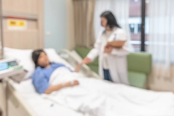 医生在医院病床上探访病人 医疗背景模糊 室内白色病房模糊 有护理或医疗康复治疗 — 图库照片