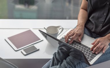 Mobil akıllı cihaz kullanan dijital iletişim yaşam tarzı blog yazarı veya kablosuz internet teknolojisi ile çalışan bilgisayar laptopunda yazan kadın kullanıcı 
