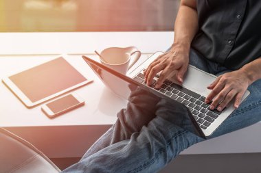 Mobil akıllı cihaz kullanan dijital iletişim yaşam tarzı blog yazarı veya kablosuz internet teknolojisi ile çalışan bilgisayar laptopunda yazan kadın kullanıcı 