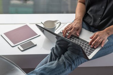 Mobil akıllı cihaz kullanan dijital iletişim yaşam tarzı blog yazarı veya kablosuz internet teknolojisi ile çalışan bilgisayar laptopunda yazan kadın kullanıcı 