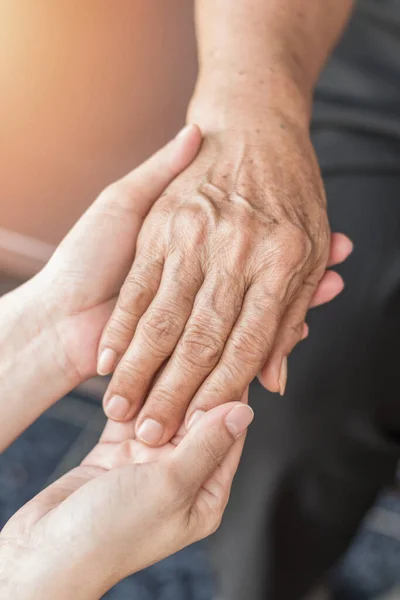 Parkinson disease patient, Alzheimer elderly senior, Arthritis person\'s hand in support of nursing family caregiver care for disability awareness day, National care givers month, ageing society