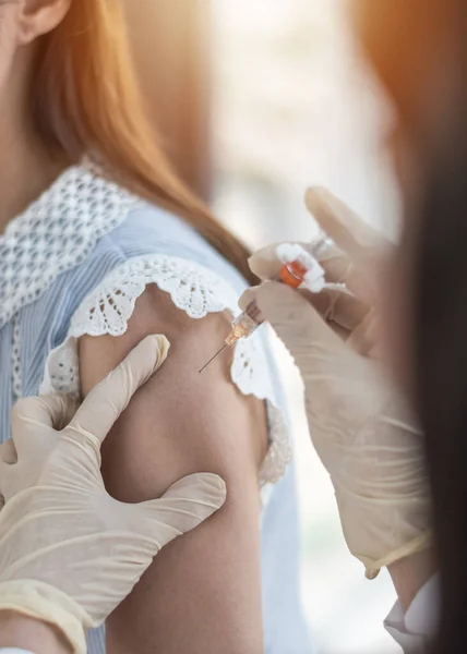 Immunization and vaccination for polio, flu shot, influenza or HPV prevention with woman having vaccine shot with syringe by nurse for World immunization week and International HPV awareness day