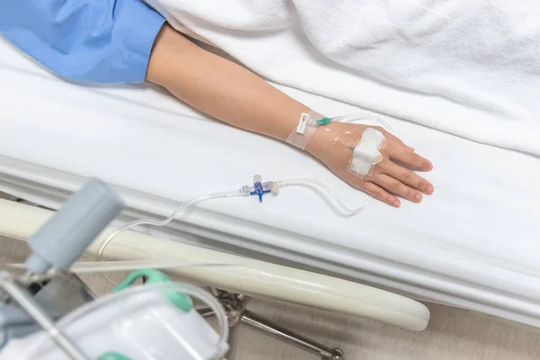 病人在医院病床上的住院病房休息 通过人工注射静脉滴注或盐水滴用于护理或疾病康复治疗 — 图库照片