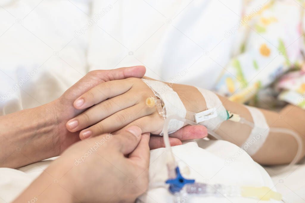 Nursing caretaker and family caregiver concept with nurse or parenting mother hand support taking care of child patient sleeping on bed in medical hospital ward or clinic room