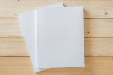 Katalog, dergi broşürü, portföy, menü tasarım şablonu için önü beyaz yüzey üzerinde ahşap masa üzerinde olan boş bir A4 kapağı boş karton kapağı modeli