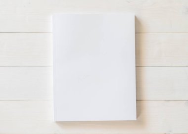 Katalog, dergi broşürü, portföy, menü tasarım şablonu için önü beyaz yüzey üzerinde ahşap masa üzerinde olan boş bir A4 kapağı boş karton kapağı modeli