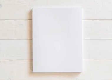Katalog, dergi broşürü, portföy, menü tasarım şablonu için önü beyaz yüzey üzerinde ahşap masa üzerinde olan boş bir A4 kapağı boş karton kapağı modeli