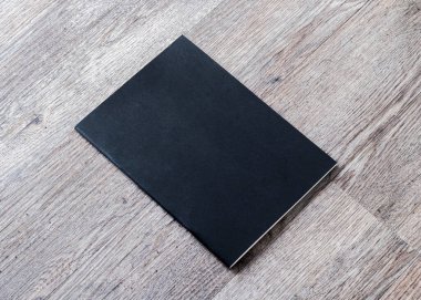 Dergi, kitapçık, broşür, menü, ahşap masa arkasındaki günlük tasarım şablonu için kitap modeli boş siyah A4 deri kapağı