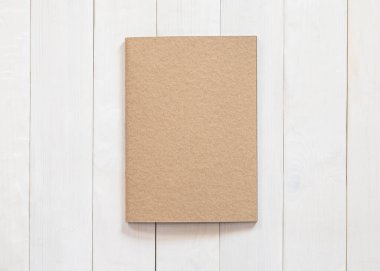 Boş kitap, B5 boyutlu katalog dergileri, broşür ya da not kapağı şablonu geri dönüşüm kahverengi kağıt dokusu düz beyaz renkli ahşap tablo üzerinde üst görünüm