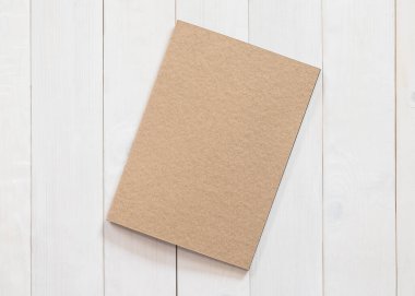 Boş kitap, B5 boyutlu katalog dergileri, broşür ya da not kapağı şablonu geri dönüşüm kahverengi kağıt dokusu düz beyaz renkli ahşap tablo üzerinde üst görünüm