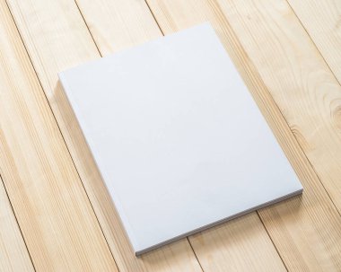 Boş kitap kapağı modelleme şablonu. Ahşap masa üzerinde beyaz yüzey üzerinde sayfa önü şablonu.