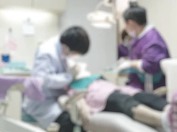 Dentistry blur background with dentist working on curing child patient who visiting dental clinic office, having teeth checkup and orthodontic operation and treatment in blurry exam room